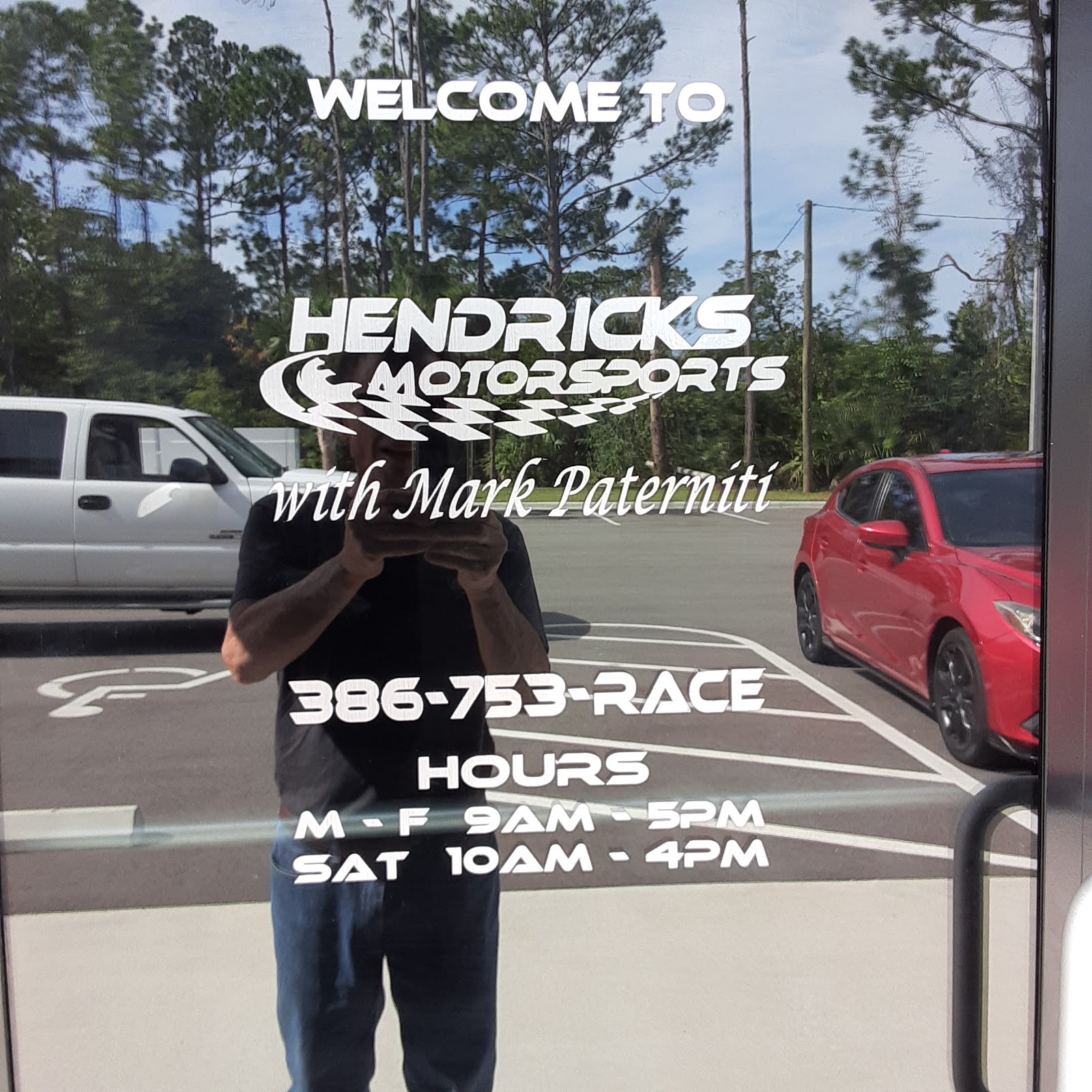 Hendricks Motorsports storefront entry — hours decal: M-F 9AM-5PM, Sat 10AM-4PM, 386-753-RACE